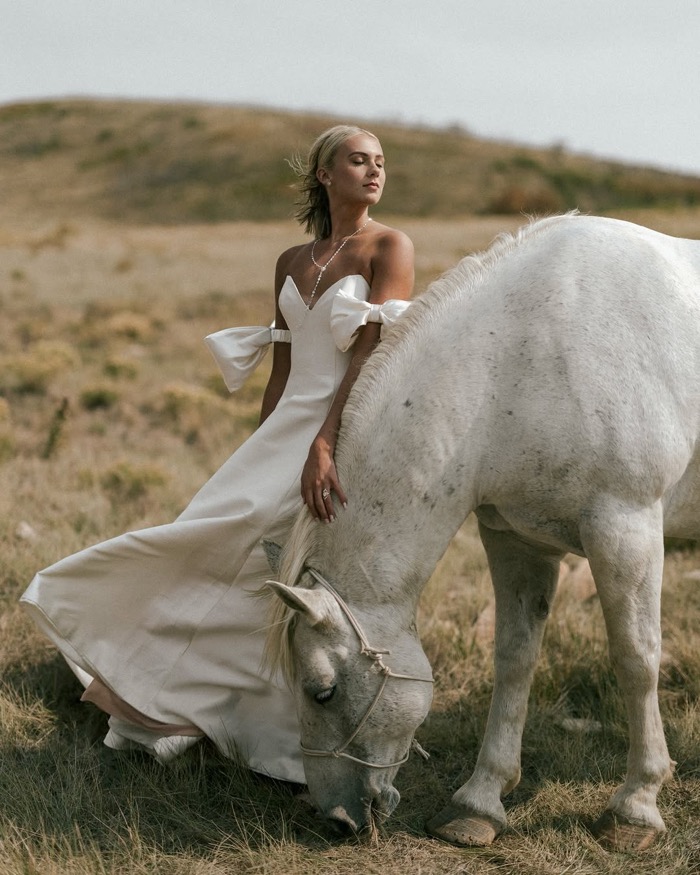 Bride with a white horse in golden hills, photographed by Paul Von Rieter
